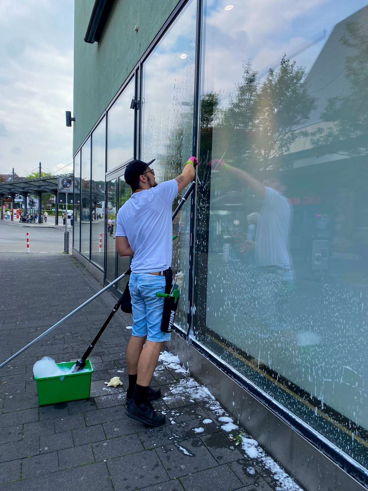 Schaufensterfront wird mit der Teleskopstange gereinigt