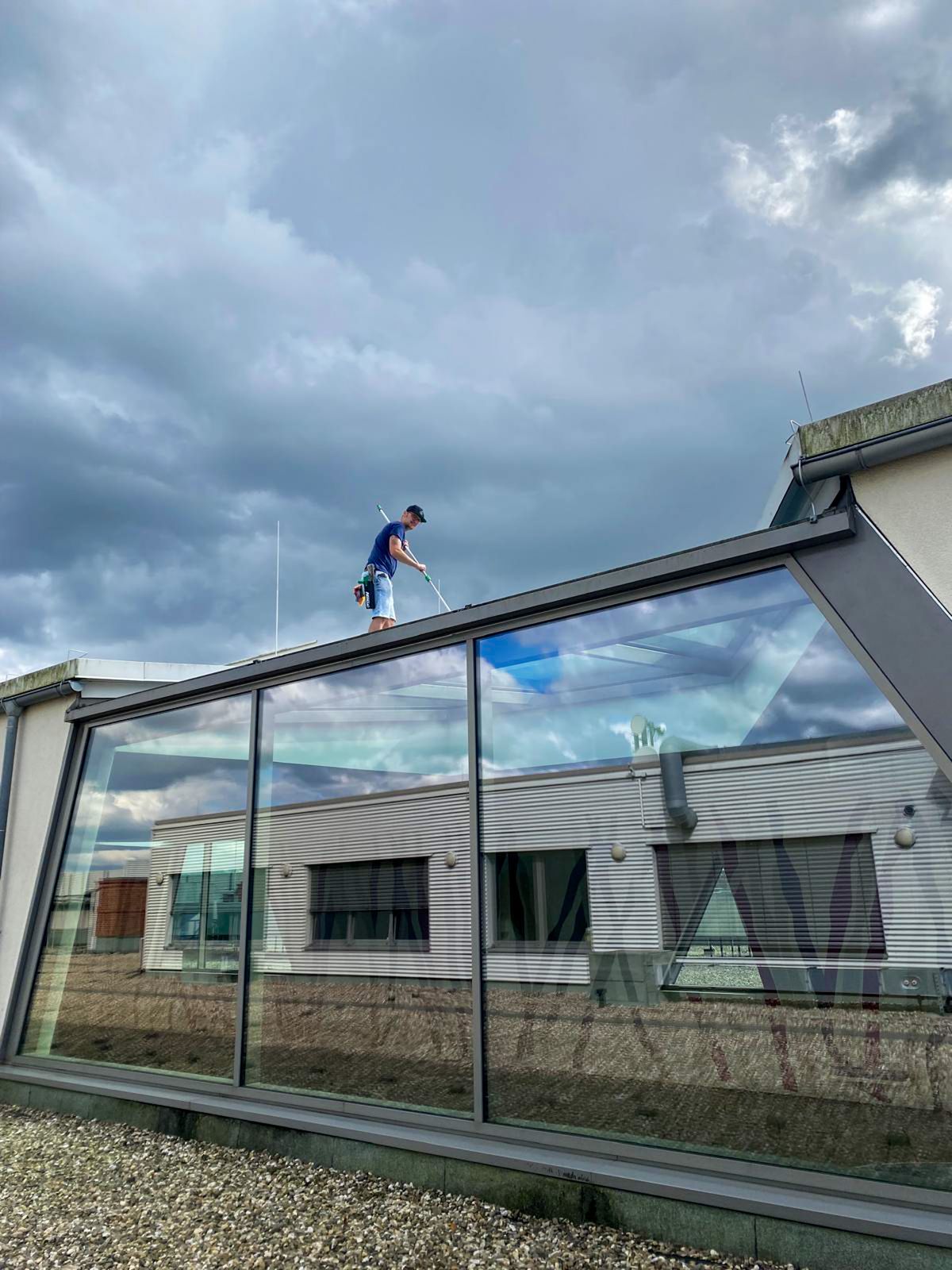 Arbeiten auf einem Glasdach bei bewölktem Himmel